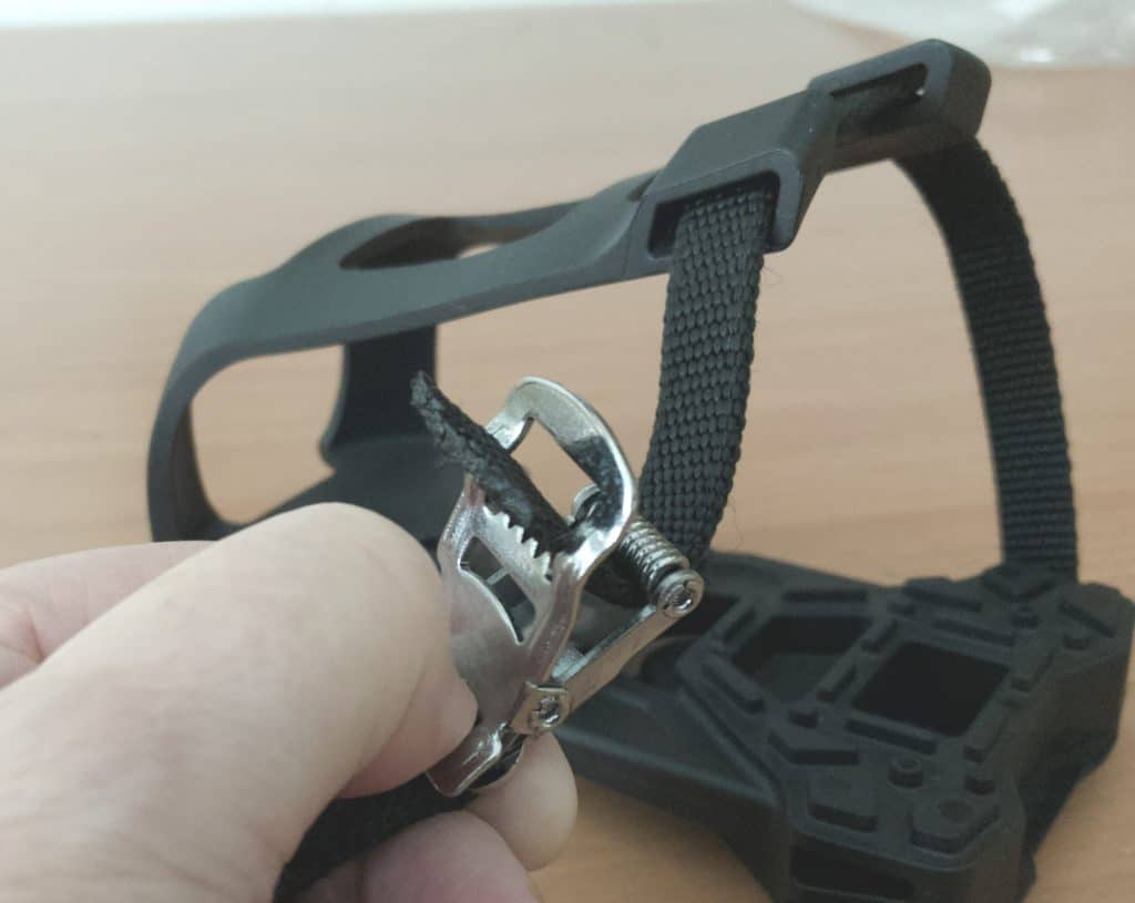 After threading the strap through the bottom and top part of each toe clip thread it through the buckle as well.