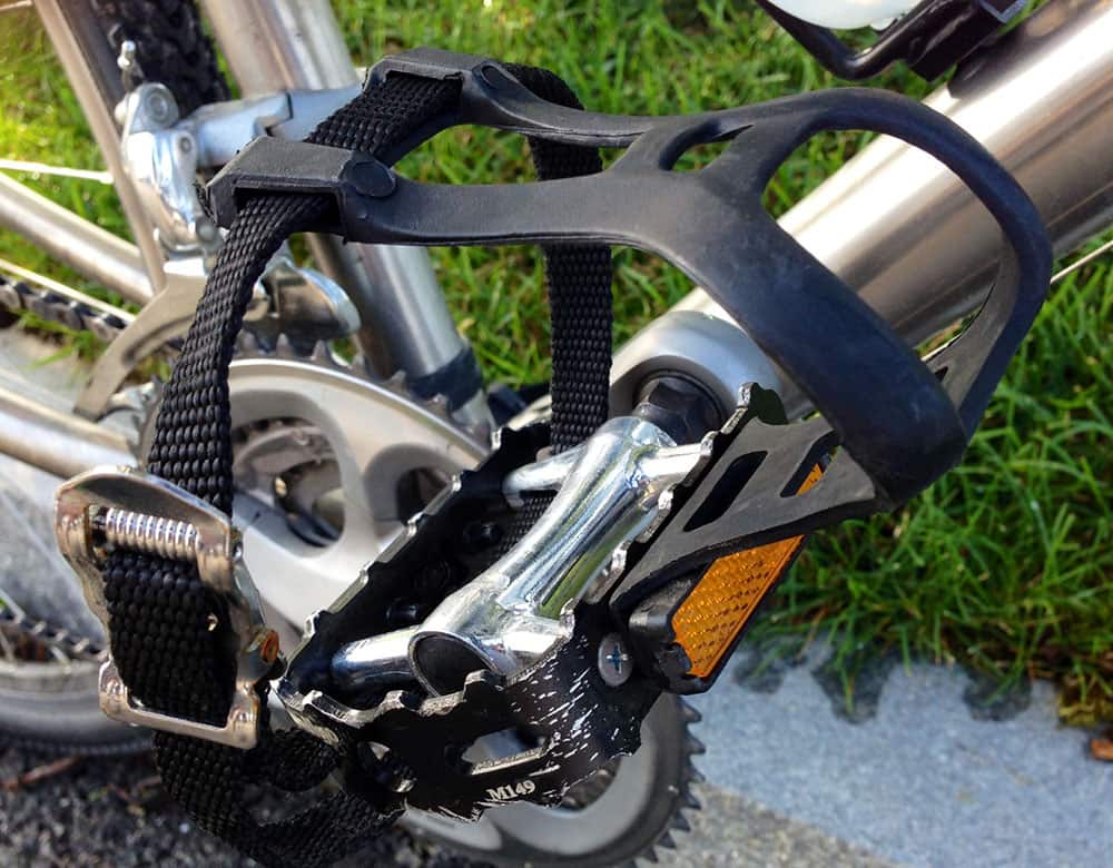 This type of mountain bike toe clip is attached to the front of the pedal and has a strap that secures the rider’s foot to the pedal.