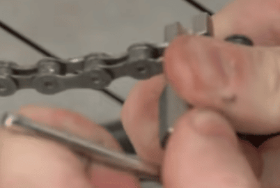 Keep applying pressure while turning the tool handle until the rivet is pushed out of the chain.