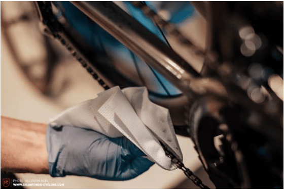 Hold a lint-free cloth around the chain and rub excess dirt off it by rotating the pedal.