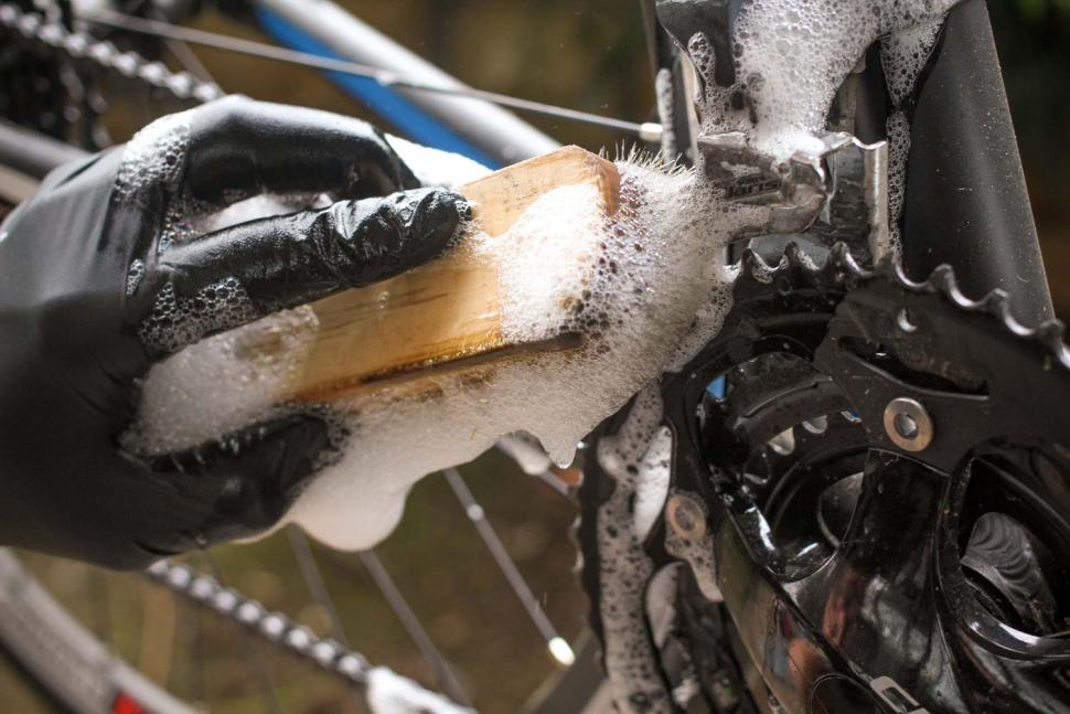 To clean off all the dirt that is caked onto your mountain bike chain, use a soft scrubbing brush and soapy water. 