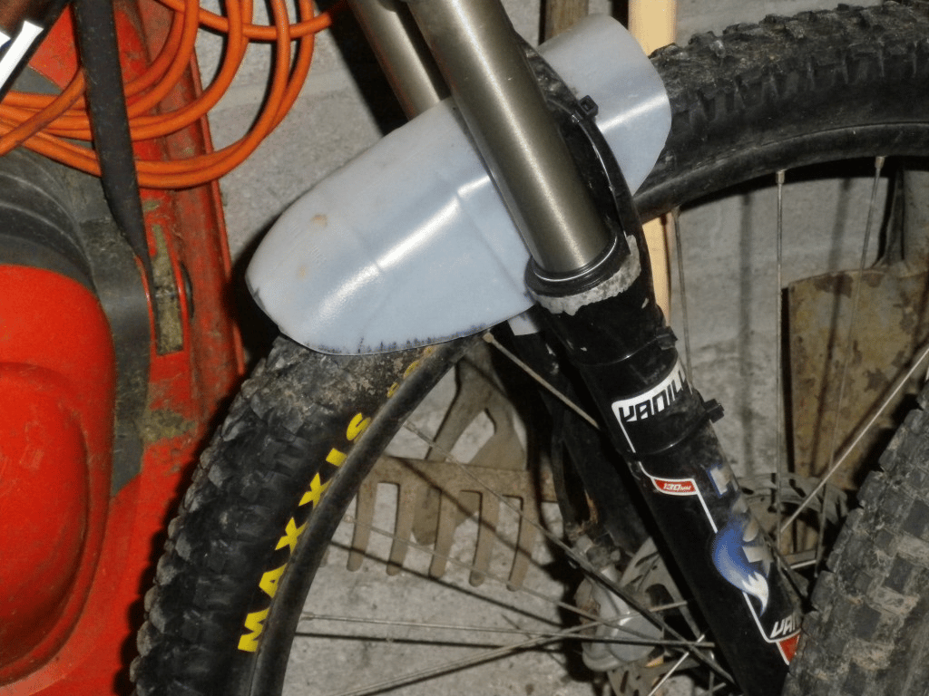 To make your mountain bike mudguard fit without touching the tire, first position it properly and then tighten the zip ties.