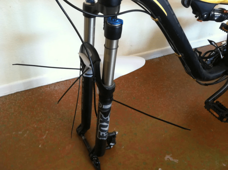 The mudguard should be slid between the front suspension fork of the mountain bike and tied through the zip tie.