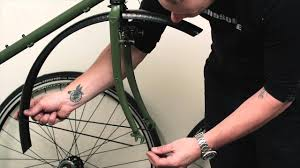 Attach the support rods of the mudguard to the eyelets of the wheel using a bolt and nut.