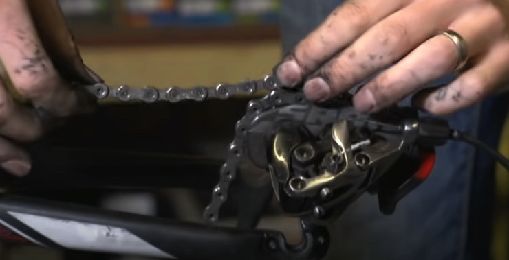 Gently spread the front knot of your tangled mountain bike chain over the pedal.