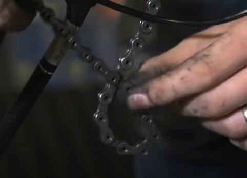 Gently spread the front knot of your tangled mountain bike chain over the pedal.