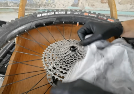 Push a folded rag between the sprockets to clean the gears.