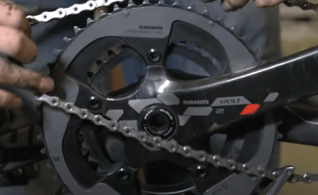 Gently place the back knot of the tangled mountain bike chain onto the chainring.