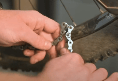 Fold the chain in half with the twisted link at the apex and apply just enough pressure to force it back into shape.